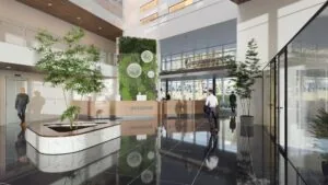 Moderne en lichte ontvangsthal van het John M. Keynesplein met een groene muur, balie en kantoorbezoekers.